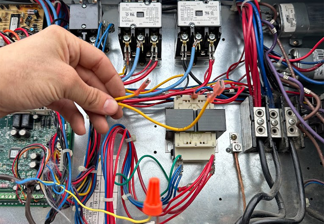 Technician assembling electrical wiring for commercial HVAC unit. Expert HVAC electrical work by Third Coast Mechanical.